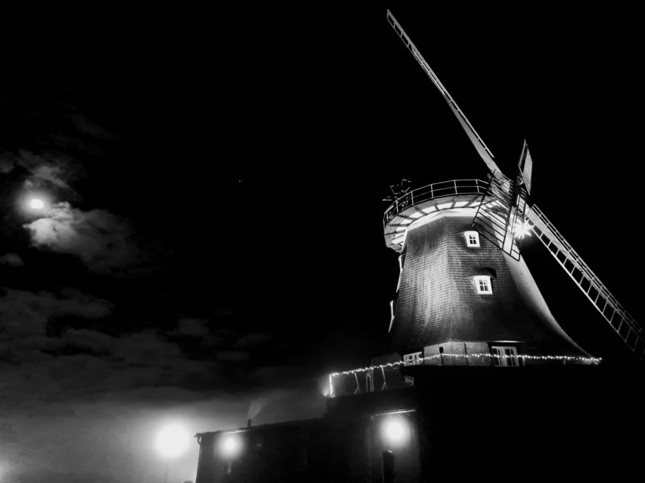 Kröpeliner Mühle bei Nacht. Der Mond scheint durch die Wolken hindurch