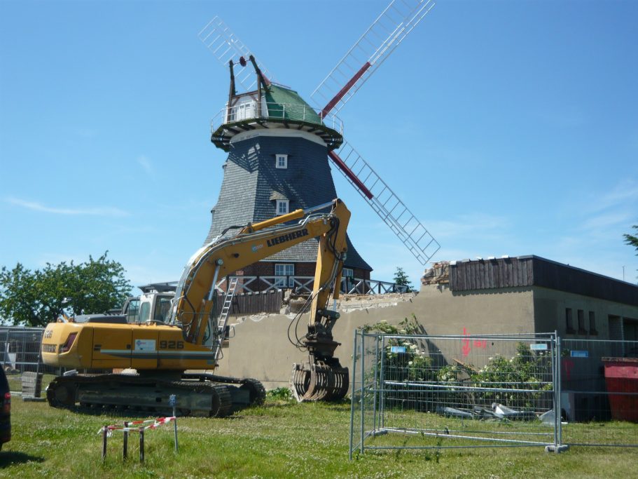 Die Sanierung der Kröpeliner Mühle 2012 mit Bagger vor der Mühle, der den Anbau abbricht